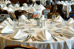 A large banquet hall is elegantly arranged with tables and chairs set up for a significant event